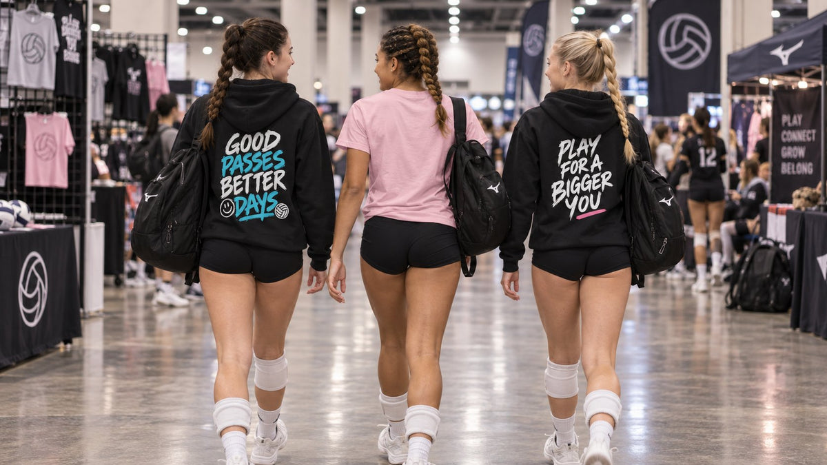 Three volleyball players walking through a tournament expo in Court Crew Co hoodies and tee